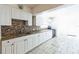 Close-up kitchen showing granite countertops, white cabinets, and tile floors at 1408 N Pine Hills Rd, Orlando, FL 32808