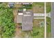 Birds eye view of home showcasing roof, driveway, a car, and yard with lush greenery at 1417 Independence Ave, Deltona, FL 32725