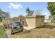 Exterior shot of a backyard featuring a Mini Cooper and a covered patio at 1417 Independence Ave, Deltona, FL 32725