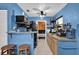 Bright kitchen with blue walls, open shelving, and an efficient layout leading into an adjacent room at 1417 Independence Ave, Deltona, FL 32725