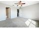 Spacious bedroom with neutral tones, carpeted floors, and a ceiling fan, illuminated by natural light at 14472 Chinese Elm Dr, Orlando, FL 32828