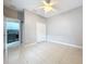 Spacious bedroom featuring tile floors, a ceiling fan, and a closet with white doors at 14472 Chinese Elm Dr, Orlando, FL 32828