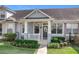 Inviting front porch with white railings, ceiling fan and tidy landscaping, creating a charming entryway at 14472 Chinese Elm Dr, Orlando, FL 32828