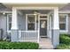 Attractive front porch with ceiling fan, white railings, and well-maintained landscaping at 14472 Chinese Elm Dr, Orlando, FL 32828