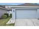 Attached one-car garage with a concrete driveway and neat landscaping at 14472 Chinese Elm Dr, Orlando, FL 32828