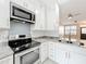 Modern kitchen with stainless steel appliances, white cabinets, and stylish backsplash at 14472 Chinese Elm Dr, Orlando, FL 32828