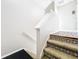 Carpeted stairs with decorative risers, a white handrail, and a view of the kitchen at 14472 Chinese Elm Dr, Orlando, FL 32828