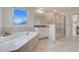 Bright bathroom features a soaking tub, glass shower, white cabinets, and ample natural light at 1472 Rushing Rapids Way, Winter Springs, FL 32708