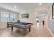 Spacious game room with a pool table, large windows, and a view into the dining area at 1472 Rushing Rapids Way, Winter Springs, FL 32708