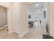 Bright hallway with modern tile flooring, leading to a billiard room and a bathroom with a shower at 1472 Rushing Rapids Way, Winter Springs, FL 32708