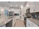 Modern kitchen featuring white cabinets, stainless steel appliances, a large island, and stylish backsplash at 1472 Rushing Rapids Way, Winter Springs, FL 32708