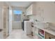 Bright laundry room with washer, dryer, and storage shelves at 1472 Rushing Rapids Way, Winter Springs, FL 32708