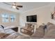 Cozy living room with large windows, a modern TV console, and a comfortable sectional sofa at 1472 Rushing Rapids Way, Winter Springs, FL 32708