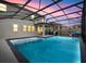 Screened-in pool with spacious patio at dusk at 1472 Rushing Rapids Way, Winter Springs, FL 32708