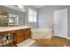 Relaxing bathroom featuring a large tub with marble surround, double sinks, and ample natural light at 15143 Ovation Dr, Winter Garden, FL 34787