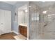 Bright bathroom featuring a glass shower, white marble, wood floor, and modern fixtures at 15143 Ovation Dr, Winter Garden, FL 34787