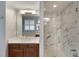 Contemporary bathroom featuring a modern vanity, large mirror, and a sleek glass-enclosed shower with elegant marble at 15143 Ovation Dr, Winter Garden, FL 34787