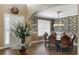 Elegant dining room featuring wood floors, designer wallpaper, and a stunning chandelier over the table at 15143 Ovation Dr, Winter Garden, FL 34787