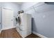 Functional laundry room with side-by-side washer and dryer, storage shelving, and wood-look floor at 15143 Ovation Dr, Winter Garden, FL 34787