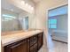 Bathroom with a large mirror, vanity, and a glass-enclosed shower, creating a practical and bright space at 20945 Oldenburg Loop, Mount Dora, FL 32757