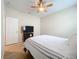 Bedroom featuring wood floor, ceiling fan and large bed beside a door and TV stand at 20945 Oldenburg Loop, Mount Dora, FL 32757