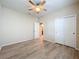 Spacious bedroom featuring wood floors, a ceiling fan, closet and connecting door to a bathroom at 20945 Oldenburg Loop, Mount Dora, FL 32757