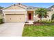 Inviting home exterior with a red door, well-kept lawn, and neutral color palette at 20945 Oldenburg Loop, Mount Dora, FL 32757