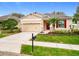 Charming single-story home with a manicured lawn, red shutters, and a two-car garage at 20945 Oldenburg Loop, Mount Dora, FL 32757