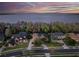Waterfront homes showcase lake views and lush greenery in a serene neighborhood setting at twilight at 210 Torcaso Ct, Winter Springs, FL 32708
