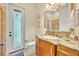 Bathroom with granite-topped vanity, decorative mirror, and a uniquely patterned glass exterior door at 210 Torcaso Ct, Winter Springs, FL 32708