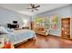 Bright bedroom with a comfortable sofa, ceiling fan and large window showing a view of the landscaping at 210 Torcaso Ct, Winter Springs, FL 32708