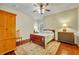 This warm bedroom features a ceiling fan, hardwood floors, and a mix of vintage and traditional furnishings at 210 Torcaso Ct, Winter Springs, FL 32708