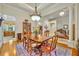 Open dining room with wood floors, a large table, and connection to the kitchen and living spaces at 210 Torcaso Ct, Winter Springs, FL 32708