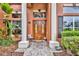 Elegant double front doors framed by white pillars, with brick pavers and manicured landscaping at 210 Torcaso Ct, Winter Springs, FL 32708