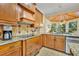 Well-lit kitchen showcasing custom cabinets, granite countertops, and a stainless steel sink overlooking the backyard at 210 Torcaso Ct, Winter Springs, FL 32708