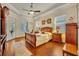 Bright main bedroom with hardwood floors, tray ceiling, and access to an outdoor area at 210 Torcaso Ct, Winter Springs, FL 32708