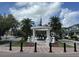 Charming town center monument with an American flag and tropical palm trees on a partly cloudy day at 210 Torcaso Ct, Winter Springs, FL 32708