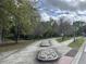 Scenic walking path with stone features and mature trees in a park-like setting on a partially cloudy day at 210 Torcaso Ct, Winter Springs, FL 32708