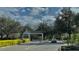 Community entrance with guard house and car entering under gate between meticulously landscaped shrubbery at 2200 Metropolitan Way # 926, Orlando, FL 32839