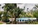 Community pool surrounded by lush palm trees with lounge chairs and yellow apartment buildings in background at 2200 Metropolitan Way # 926, Orlando, FL 32839