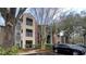 Apartment building exterior showcasing brick and siding with balconies, a parking area, and mature trees at 2200 Metropolitan Way # 926, Orlando, FL 32839