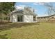 Spacious backyard featuring a well-maintained lawn and the rear exterior of the home with a sliding glass door at 2206 W Pine St, Orlando, FL 32805