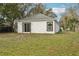 View of the backyard showing the exterior with white siding and sliding glass door at 2206 W Pine St, Orlando, FL 32805