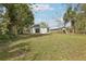 Expansive backyard with trees, grass, and rear exterior view of the home with sliding glass doors at 2206 W Pine St, Orlando, FL 32805