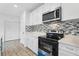 Close-up of the modern kitchen features stainless steel appliances and a stylish backsplash at 2206 W Pine St, Orlando, FL 32805