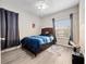 Bedroom with grey wood-look floors, ceiling fan, and window bringing in natural light at 2336 Caravelle Cir, Kissimmee, FL 34746