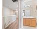 Upstairs hallway featuring wood-look floors, white railing and an open bathroom entrance at 2336 Caravelle Cir, Kissimmee, FL 34746