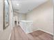 Bright hallway with wood-look floors, neutral walls, and white railing overlooking the stairwell at 2336 Caravelle Cir, Kissimmee, FL 34746