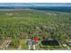 An expansive aerial view captures the home amidst lush trees and a tranquil pond at 2875 E Slater Dr, Deltona, FL 32738