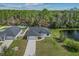 An aerial view of a single-story home with a pond, trees, and a neighboring home at 2875 E Slater Dr, Deltona, FL 32738